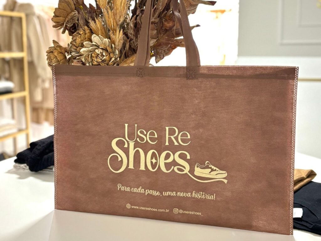 A sacola de TNT da loja de calçados exemplifica como agregar valor ao produto usando embalagens sustentáveis que fortalecem a identidade da marca.