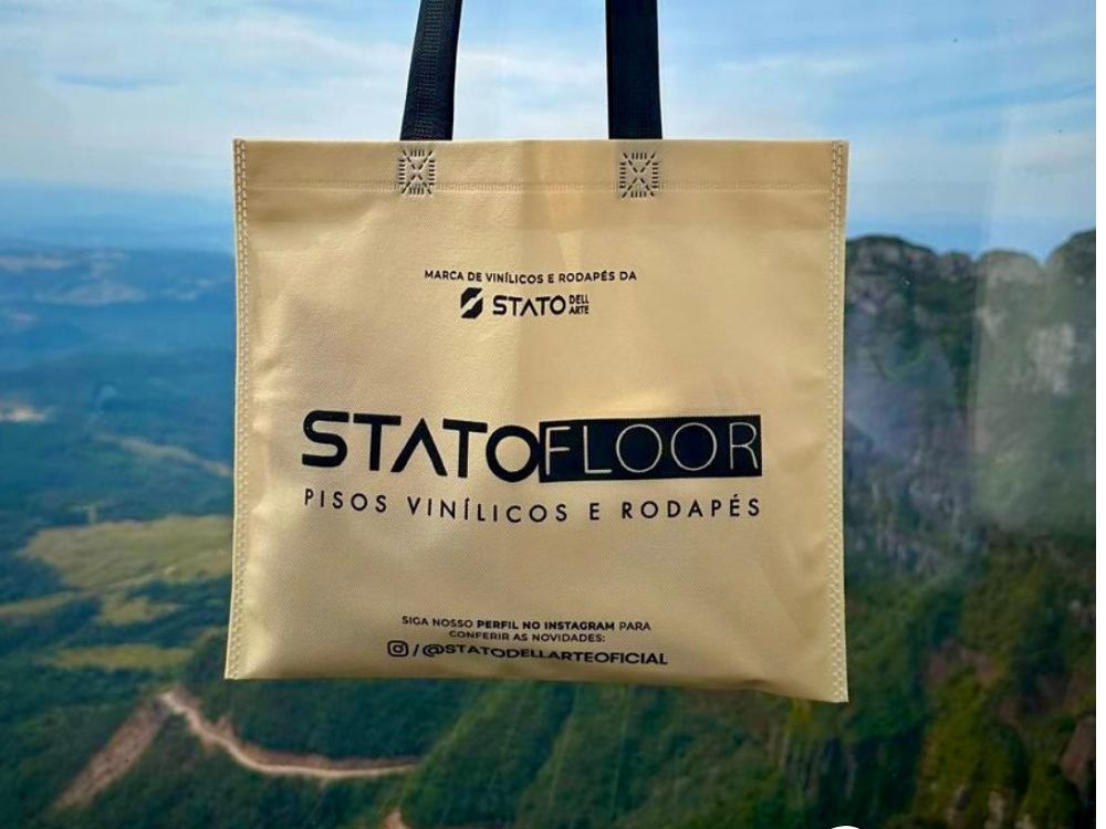 A foto da sacola da "STATOFLOOR" exemplifica o uso de materiais sustentáveis e a promoção da marca através de embalagens e produtos reutilizáveis. Isso reforça a ideia de uma estratégia de marketing empresarial que se traduz em ações práticas e tangíveis