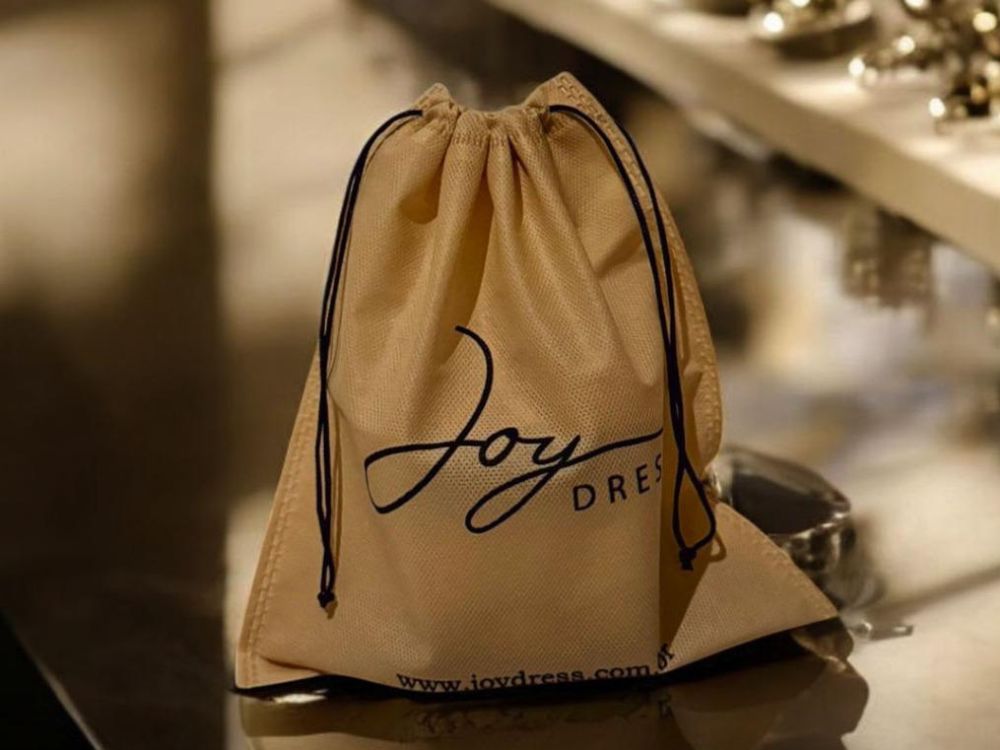 Saquinho de TNT personalizado da Joy Dress, exemplo de embalagem ecológica reutilizável que representa o conceito de produtos sustentáveis.