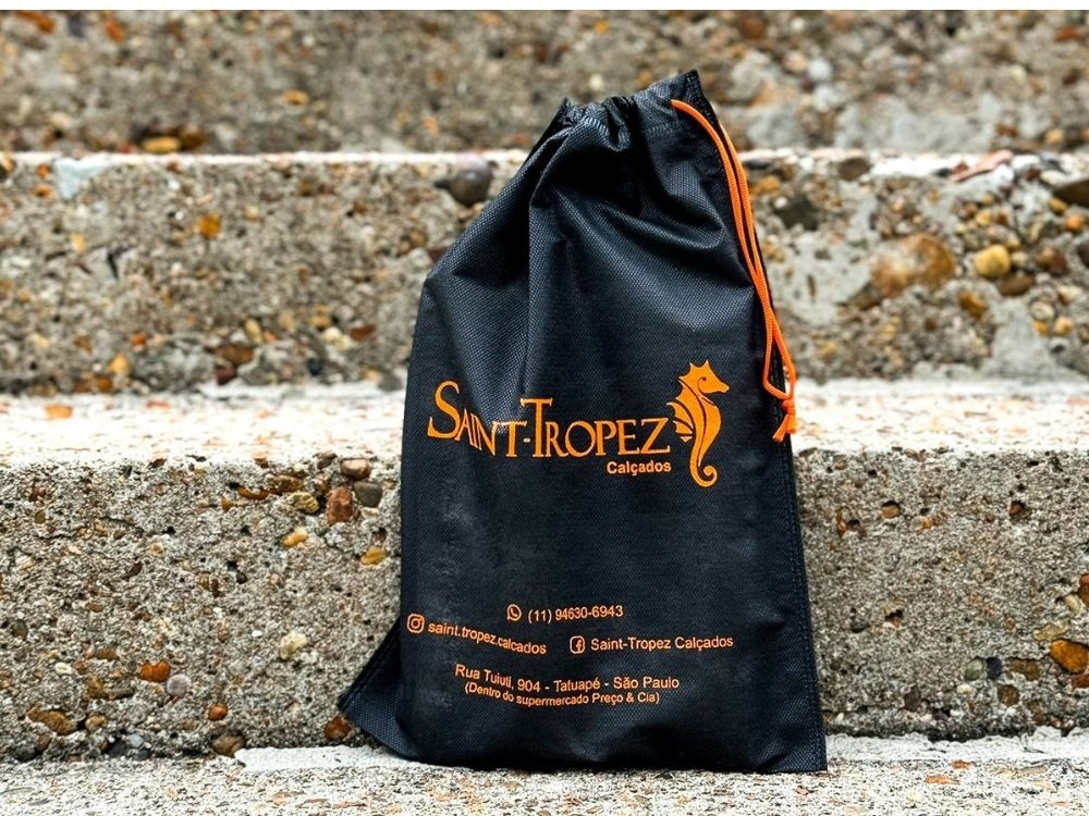 Saquinho de TNT preto com logotipo Saint-Tropez Calçados, alternativa ecológica e durável dentro da categoria de produtos sustentáveis.