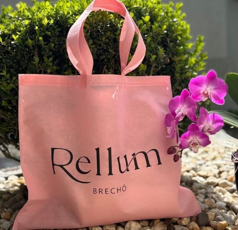Sacola rosa de TNT da marca Rellum Brechó, exemplo moderno e estiloso entre as diversas opções de produtos sustentáveis reutilizáveis.
