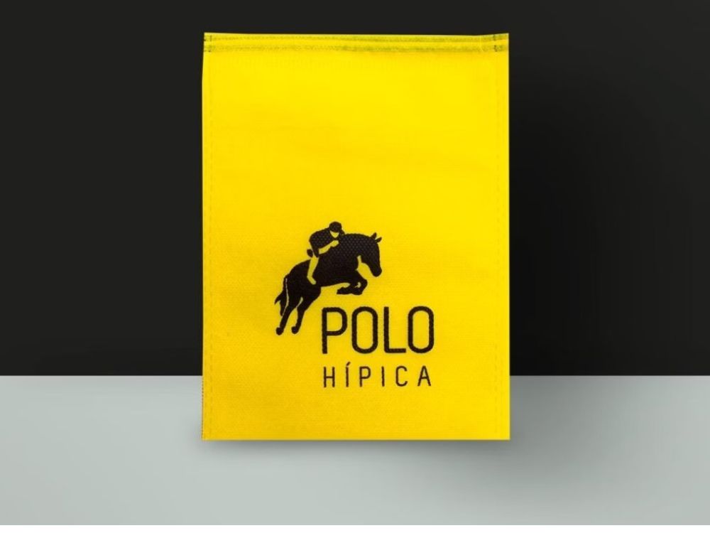 Saquinho TNT amarelo com logotipo de marca. Sacolas personalizadas são práticas e fazem parte das 6 ideias para presentear clientes com estilo.