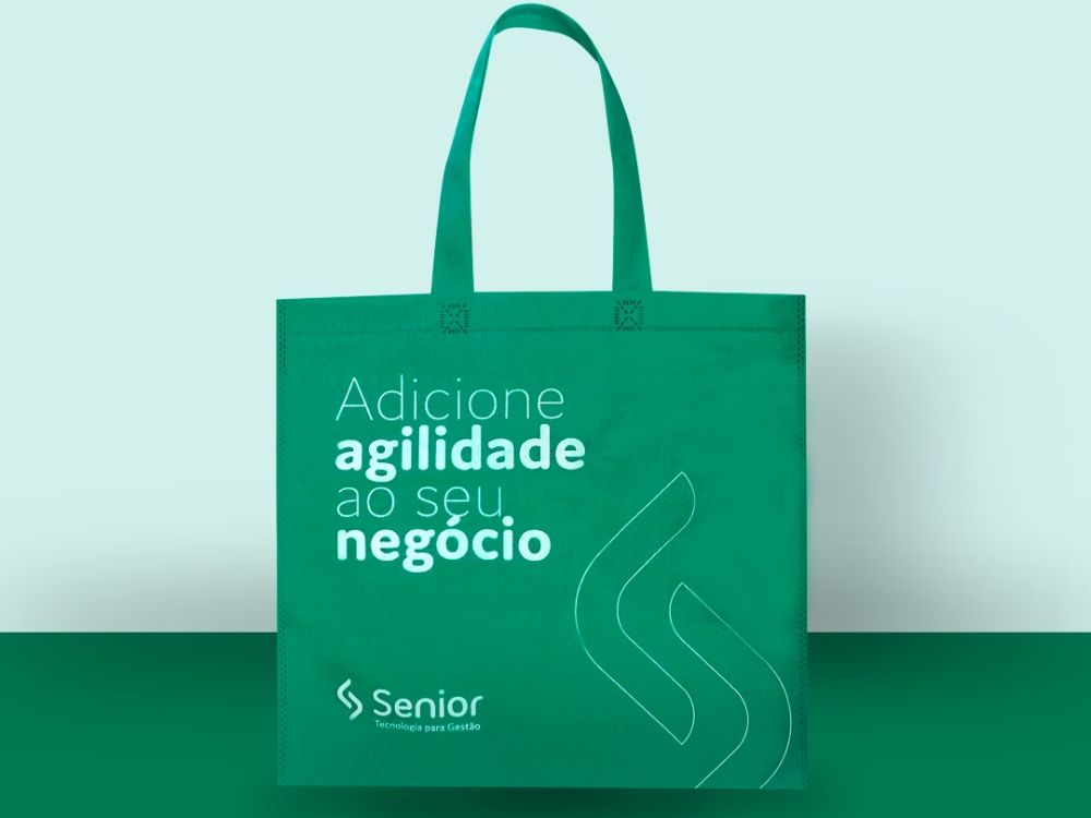 Sacola ecológica em TNT verde com estampa institucional, exemplo de o que são embalagens eco friendly no ambiente corporativo.