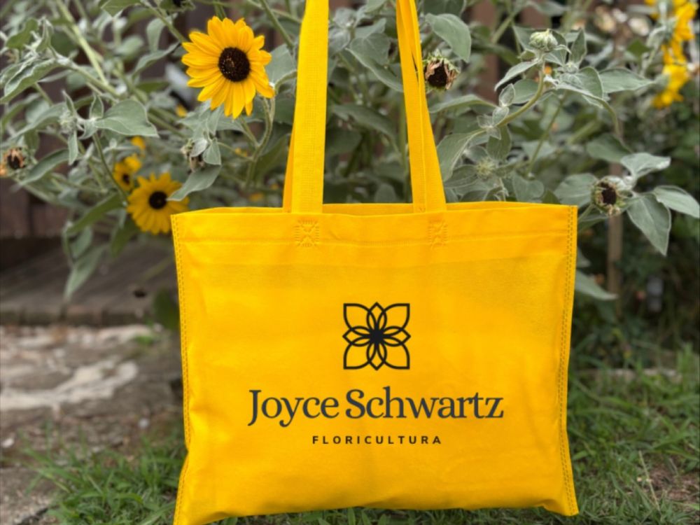 Sacola reutilizável em TNT com identidade visual de floricultura, exemplo prático de o que são embalagens eco friendly usadas no varejo sustentável.