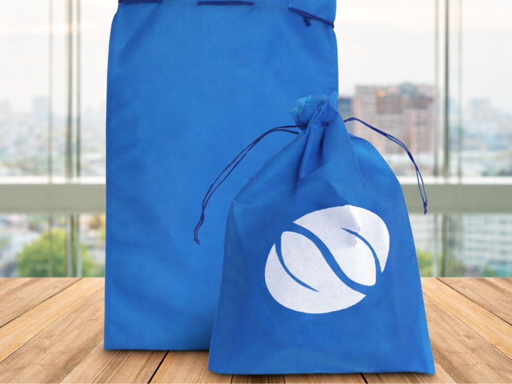 Embalagens ecológicas personalizadas em TNT com logotipo, utilizadas como brinde corporativo em estratégia de Ativação de marca em eventos.