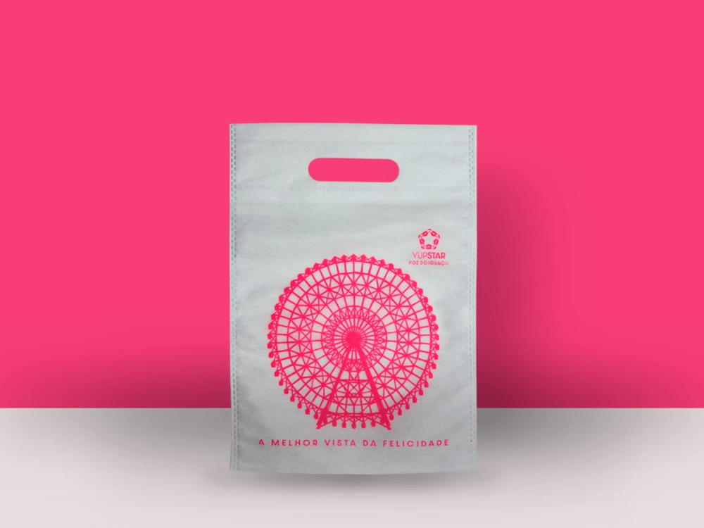 Sacola de TNT personalizada com alça vazada e impressão em rosa, destacando uma solução reutilizável para embalagens inovadoras e sustentáveis.