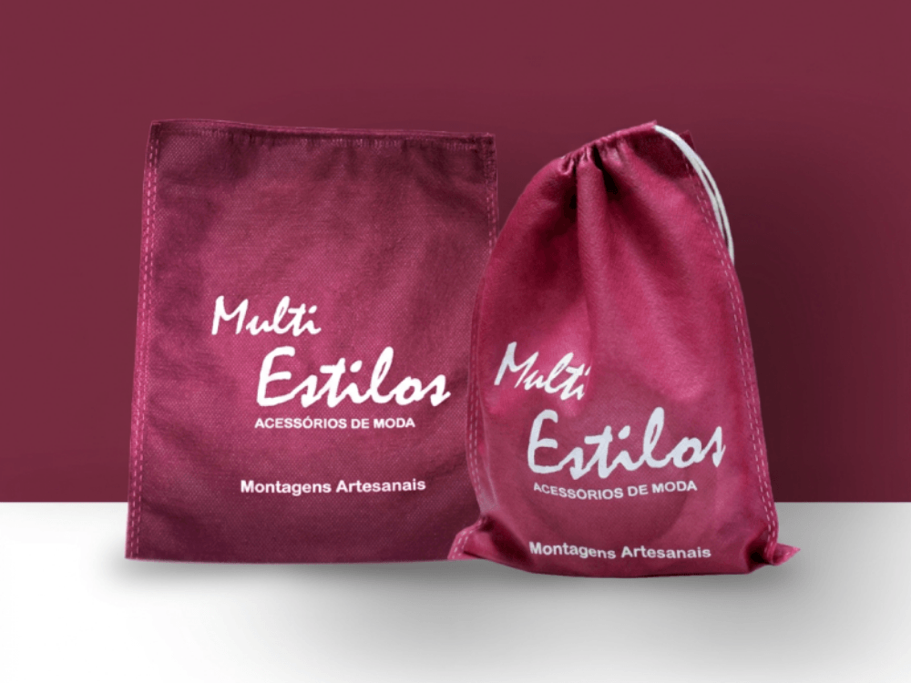 Duas sacolas de TNT personalizadas na cor vinho, com diferentes formatos e logotipo de uma marca de acessórios. Tudo para explicar como lavar TNT.