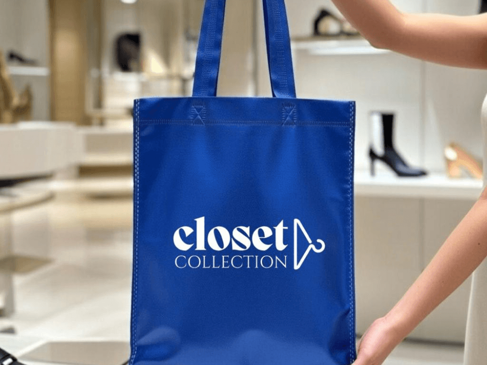 Sacola azul de material não tecido com alças e logotipo Closet Collection, usada como embalagem personalizada para loja.