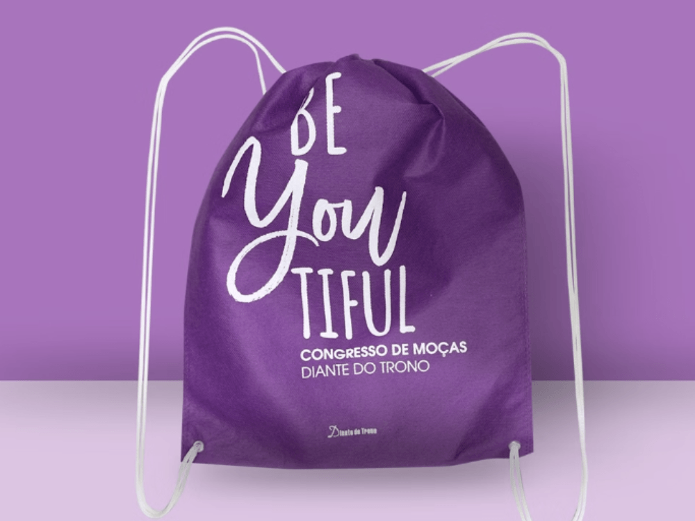 Mochila-saco roxa personalizada para o Congresso de Moças Diante do Trono, com alças brancas e impressão em destaque.