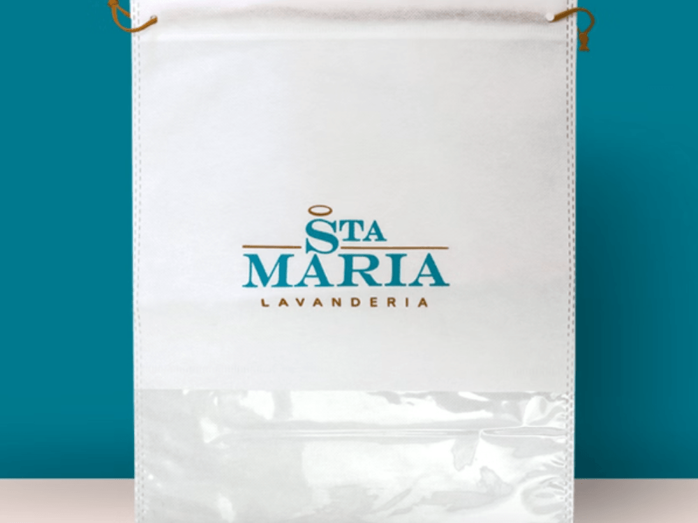Sacola branca personalizada da lavanderia Santa Maria, com fechamento por cordão e compartimento transparente na parte inferior.