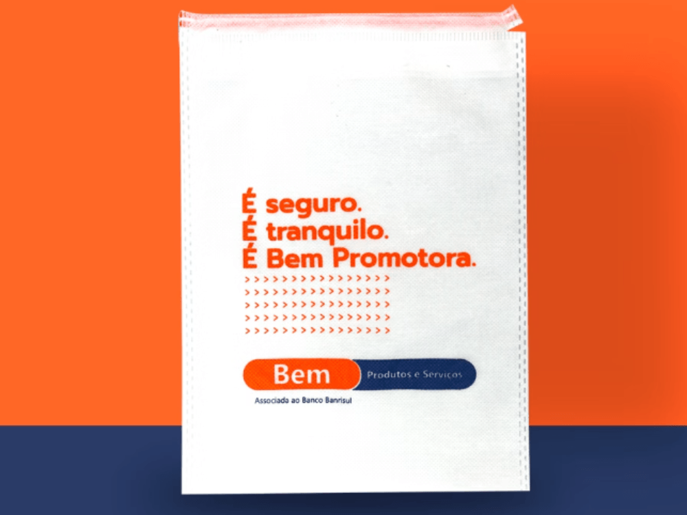 Sacola promocional branca da Bem Promotora com impressão em laranja e azul, exemplo de embalagem personalizada para empresas. Tudo para explicar o conceito de embalagem primária, secundária e terciária.